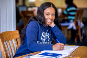 student studying, smiling at the camera